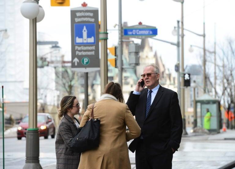 Blair talks on his phone while he stands with staff on Wellington Street in Ottawa on March 13, 2020 (CP/Sean Kilpatrick)