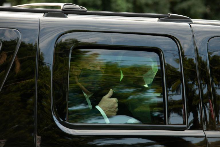 Trump wears a protective mask as he is driven in a motorcade past supporters outside of Walter Reed National Military Medical Center in Bethesda, Maryland, on Oct. 4, 2020 (Graeme Sloan/Bloomberg via Getty Images)