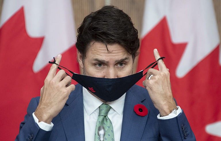 Trudeau puts on his mask after speaking during a news conference in Ottawa on Nov. 6, 2020 (CP/Adrian Wyld)