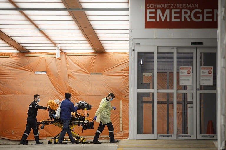 Paramedics wheel a patient into the emergency department at Mount Sinai Hospital in Toronto, on Jan. 13, 2021 (CP/Cole Burston)