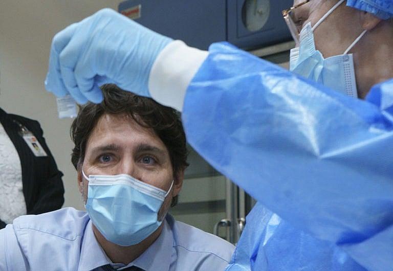 <p>Trudeau looks at a COVID-19 vaccine vial as he tours a  vaccination clinic in Montreal on March 15, 2021 (CP/Paul Chiasson)</p>
