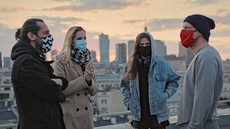 Young people meeting on a rooftop. Wearing masks and keeping distance
