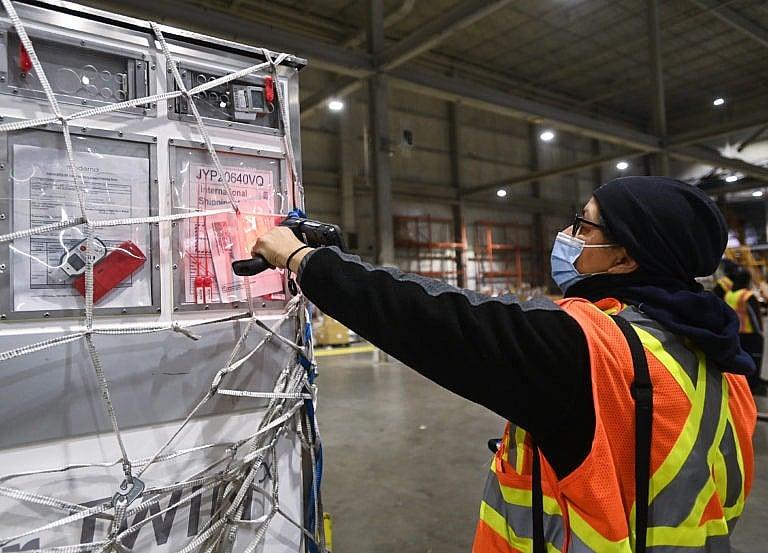 A FedEx worker scans a shipment of the Moderna COVID‑19 vaccine at Pearson International Airport in Toronto on March 24, 2021 (Nathan Denette/CP)