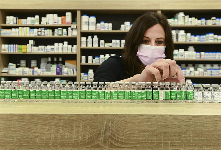 Pharmacist Barbara Violo arranges all the empty vials of the Oxford-AstraZeneca COVID-19 vaccines that she has provided to customers at the Junction Chemist in Toronto, on April 19, 2021. (CP/Nathan Denette)