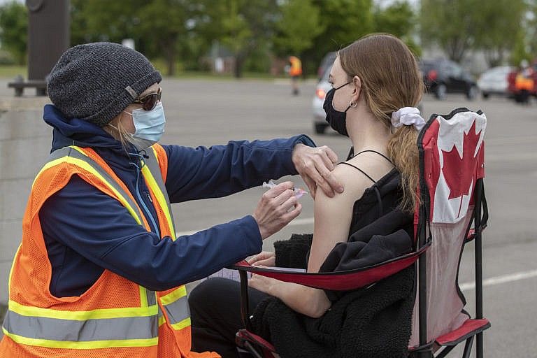 A person receives a COVID-19 vaccine at a drive-thru clinic in Kingston, Ont., on May 28, 2021 (Lars Hagberg/CP)