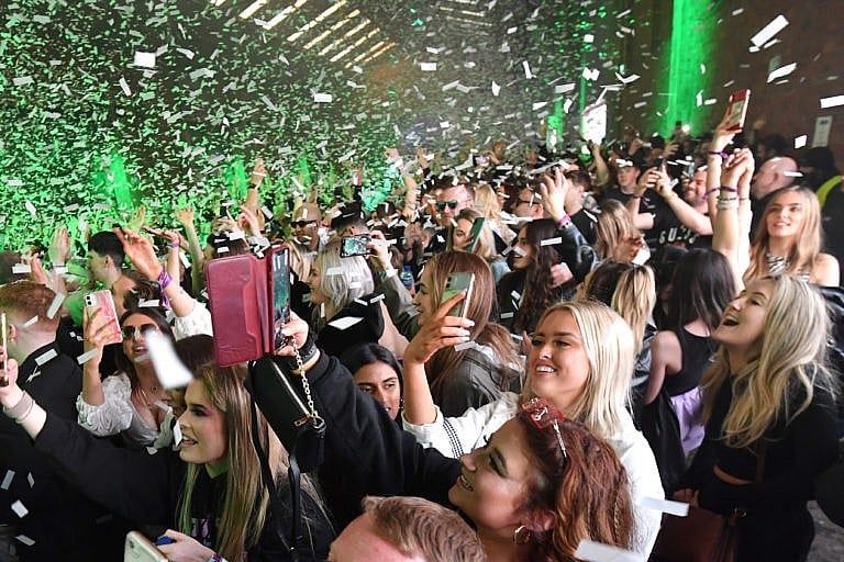 Confetti is fired into the crowd as Nightclub Circus hosts the first dance event, which will welcome 6,000 clubbers to the city's Bramley-Moore Dock warehouse on April 30, 2021 in Liverpool, England. The event is part of the national Events Research Programme which will provide data on how events could be permitted to safely reopen. (Anthony Devlin/Getty Images)