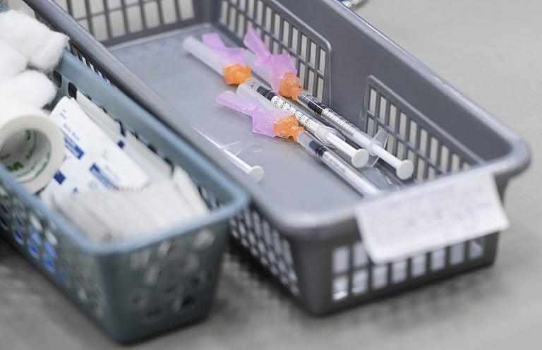 Needles containing COVID-19 vaccine wait to be administered to patients at a clinic in Ottawa on March 30, 2021 (Sean Kilpatrick/CP)