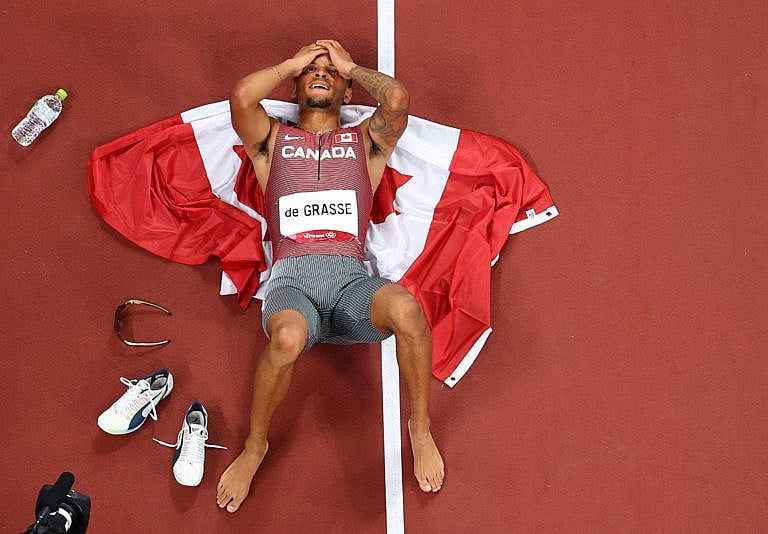 Gold medallist Andre De Grasse of Canada lies on the track after winning the Men's 200m. (Fabrizio Bensch/Reuters)