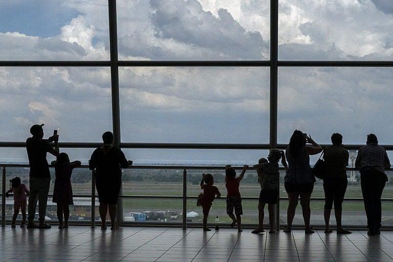 Families watch planes on the tarmac at Johannesburg's OR Tambo's airport, Nov. 29, 2021. WHO urged countries around the world not to impose flight bans on southern African nations due to concern over the new Omicron variant. (AP Photo/Jerome Delay)