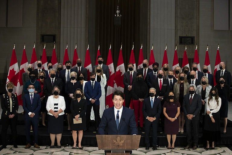 The newly sworn-in federal cabinet listens to Prime Minister Justin Trudeau during a press conference in Ottawa on Oct. 26, 2021 (Lars Hagberg/CP)