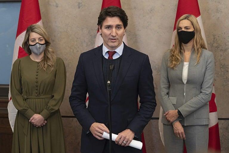 Foreign Affairs Minister Melanie Joly (left) and Sport Minister Pascale St-Onge look on as Canadian Prime Minister Justin Trudeau announces Canada will join a diplomatic boycott of the Winter Games in China following caucus, Wednesday, December 8, 2021 in Ottawa. THE CANADIAN PRESS/Adrian Wyld