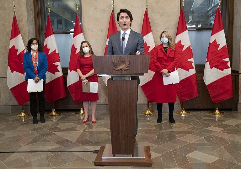 Defence Minister Anita Anand, Deputy Prime Minister and Finance Minister Chrystia Freeland and Foreign Affairs Minister Melanie Joly look on as Prime Minister Justin Trudeau speaks, Jan. 26, 2022 in Ottawa. (Adrian Wyld/The Canadian Press)