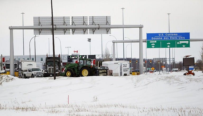 People block highway 75 with heavy trucks and farm equipment and access to the Canada/US border crossing at Emerson, Man., Feb. 10, 2022. (John Woods/The Canadian Press)