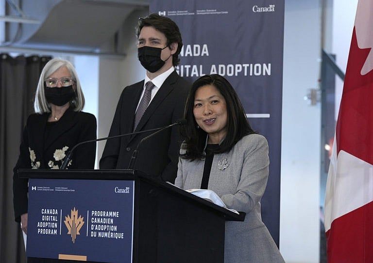 Trudeau listens as Ng speaks at a news conference on the Canadian Digital Adoption Program at Bayview Yards in Ottawa, on March 3, 2022 (Justin Tang/CP)