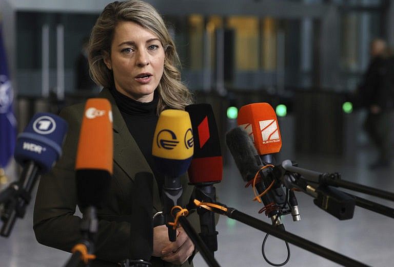Canadian Foreign Minister Melanie Joly speaks with the media as she arrives for a meeting of NATO foreign ministers at NATO headquarters in Brussels, April 7, 2022. (Olivier Matthys/AP Photo)