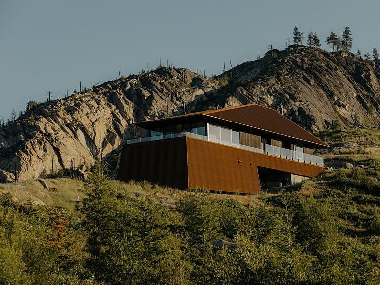 A maroon coloured home nestled in hills