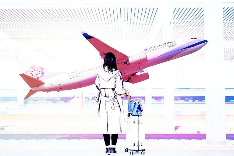 A photo-illustration of a woman standing beside a rolling suitcase, looking at an airplane